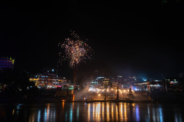 Fototapeta na wymiar The Ganga River reflecting the festivities in the temples during the night.