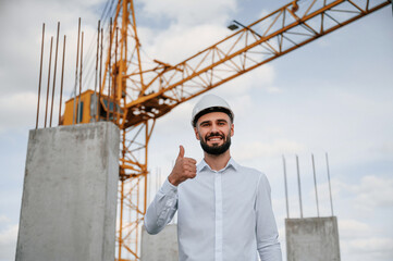 Naklejka na ściany i meble Smiling and showing thumb up. Man in uniform is working on the construction site