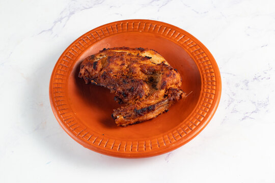 bbq chicken breast piece served in a dish isolated on background side view