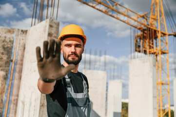 Stop gesture. Man in uniform is working on the construction site