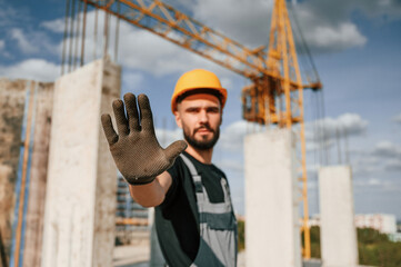 Stop gesture. Man in uniform is working on the construction site
