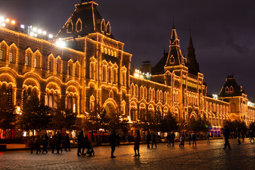 Fototapeta premium MOSCOW, RUSSIA - October 6, 2022: Golden building GUM burning with evening magic illumination. New Year and Christmas atmosphere in the center of Moscow