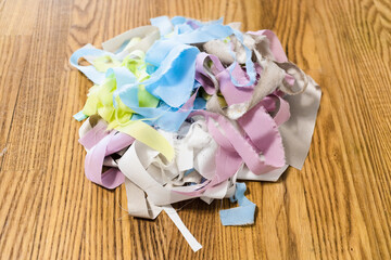 pile of shreds of silk cloth for patchwork on wooden table