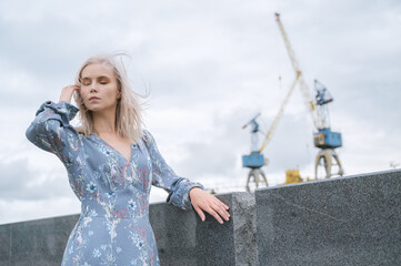 Woman in blue dress enjoys sea shore.