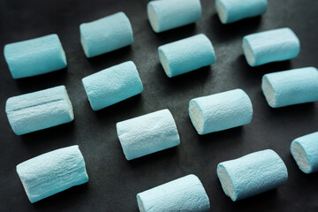 Blue marshmallows on dark background.