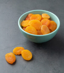 Dried apricots on a bowl over stone background