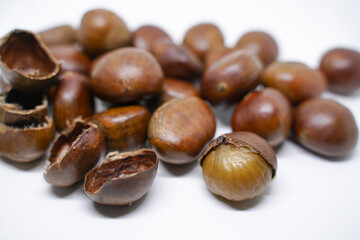 Fresh chestnuts with peeled roasted chestnuts isolated on a white background, chestnuts have an oily sweet taste.