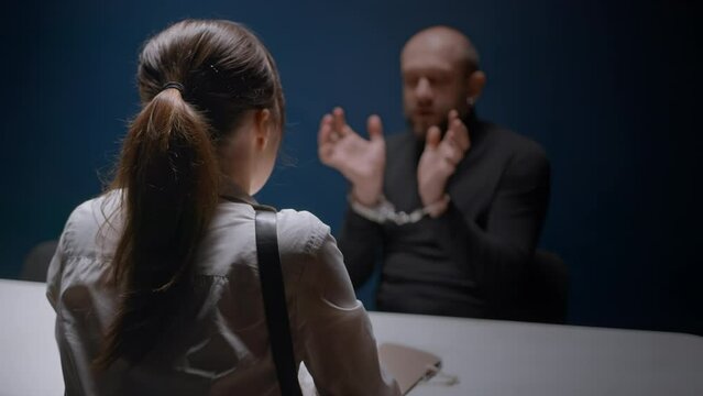 Male suspected criminal demands and asks to give him phone to call his lawyer. Female detective in interrogation of detained man in handcuffs. FBI agent cop and Russian mafia. Police officer, evidence