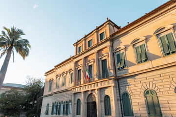 Obraz premium Beautiful old vintage building with a palm tree at sunset in Italy