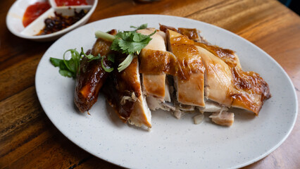 chopped tasty roast chicken on a white plate also served with sauce. it is usually served with hainam rice