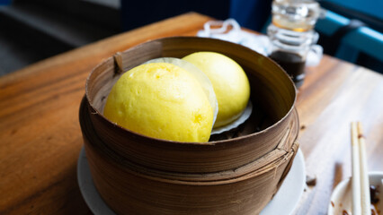 two yellow hot buns on dimsum bamboo plate