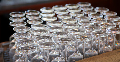 Viele saubere Weingläser warten am Tresen auf ihre Befüllung.
