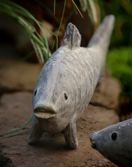 Die Skulptur, Figur eines Fisches am Rand eines Goldfischteichs.