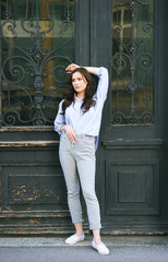 Fashion portrait of beautiful young woman, wearing blue shirt, posing outdoors