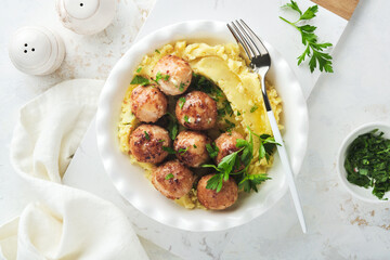 Swedish meatballs in cream sauce, potatoes and lingonberry sauce in bowl on slate, stone or concrete backgrounds. Swedish cuisine. Delicious creamy mashed potatoes. Top view.