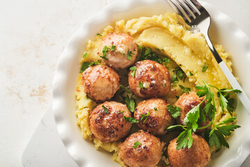 Swedish meatballs in cream sauce, potatoes and lingonberry sauce in bowl on slate, stone or...