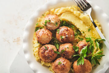 Swedish meatballs in cream sauce, potatoes and lingonberry sauce in bowl on slate, stone or concrete backgrounds. Swedish cuisine. Delicious creamy mashed potatoes. Top view.