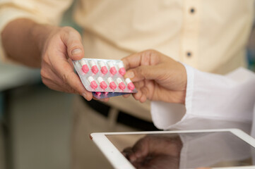 A young man receives pills from a pharmacist in a pharmacy.
