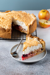 Apple pie with berries and meringue on top. Homemade apple tart on concrete background.
