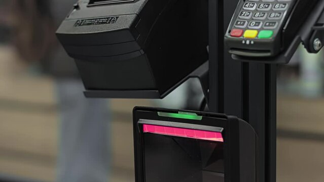 Blinking flashing scanner for reading barcodes at self-service checkout SCO. Assisted checkout ACO with cashless payment in supermarket. Shopping at mall and store. Closeup electronic laser device