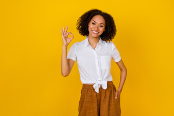 Photo of optimistic wavy hairdo millennial lady show okey wear white blouse isolated on yellow color background