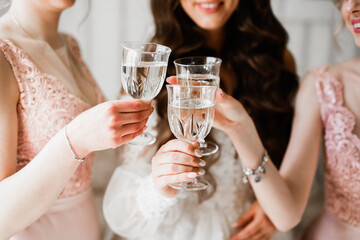 Photo bride with her friends drinking champagne from glasses