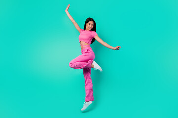 Full length photo of cheerful lady jump high enjoying moving wear trend clothes isolated cyan color...