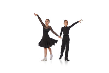 Cha cha cha, rumba, tango. Two kids, school age girl and boy in black stage costumes dancing ballroom dance isolated on white background. Motion, action, hobbies - obrazy, fototapety, plakaty