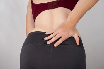 pain hernia of the lower vertebrae, the woman holds her hand to the lower back