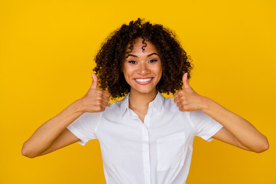 Photo of pretty positive girl beaming smile hands fingers show thumb up approve rate isolated on yellow color background