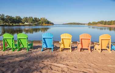 Fototapeta na wymiar Colourful deck chairs on autumn beach