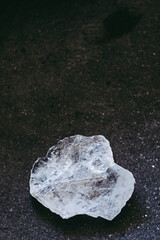 Galet pierre brute cristal de roche sur un fond noir - Minéral naturel