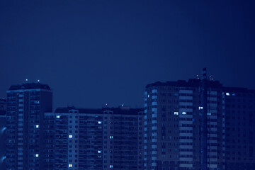 Multi-storey building with dark windows at night. Blackout in the city. Electricity shutdown. Power...