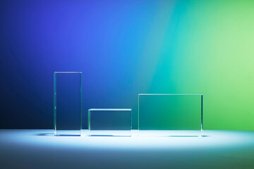 Rectangular glass platforms for product promotion on the gradient blue and green background. Minimal scene with podium