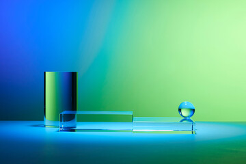 Front view of a transparent pedestal with an abstract gradient background of blue and green....