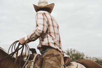 Cowboy in saddle horseback on ranch for western industry lifestyle concept. - obrazy, fototapety, plakaty