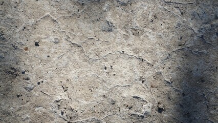 The texture of a smooth relief gray rock with crevices top view large, stone, asphalt