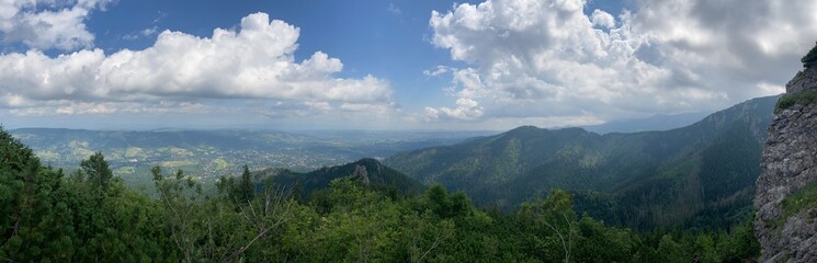 Sunny summer hiking path in the mountains. Rocky Mountain in the summer with trees and forest. Walking in the mountains and forest with blue sky. Summer travel hiking in Europe. 