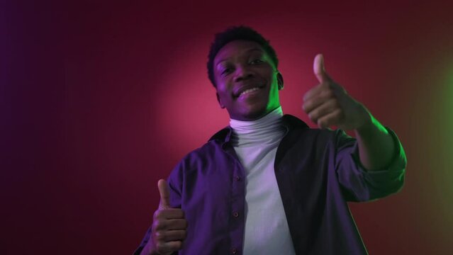Like gesture. Neon people. Choice approval. Satisfied smiling guy supporting idea with thumb up on purple red color gradient light background.