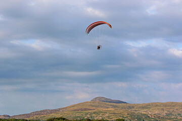 Fototapeta na wymiar Paramotor pilot flying in the hills of Wales