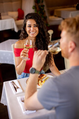 Young couple having lunch with white wine in the restaurant