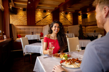 Young couple having lunch with white wine in the restaurant