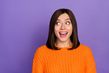 Photo portrait of nice young woman look excited empty space wear trendy knitwear orange garment isolated on violet color background