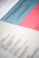 Postal voting (Briefwahl) documents for the upcoming government, red and blue envelope. Document politically. Selective focus. diagonally.