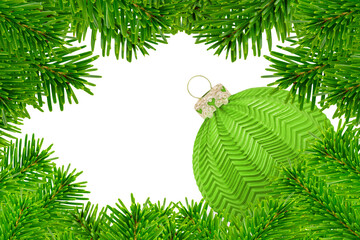 Dekoration für Weihnachten mit grüner Weihnachtskugel und Tannenzweigen auf weissem Hintergrund