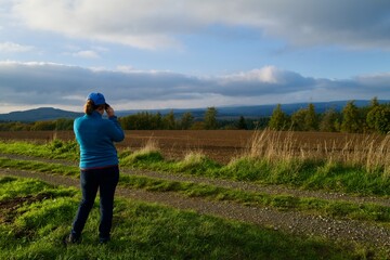 woman observing in the field with a binoculars