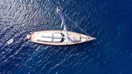 Aerial drone top down photo as seen from top of mast of beautiful sail boat with wooden deck...