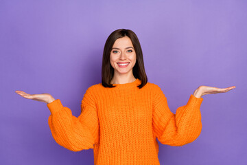 Photo portrait of nice young lady palms scales compare product dressed stylish knitted orange...