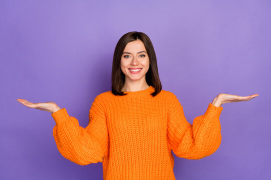 Photo portrait of nice young lady palms scales compare product dressed stylish knitted orange outfit isolated on purple color background