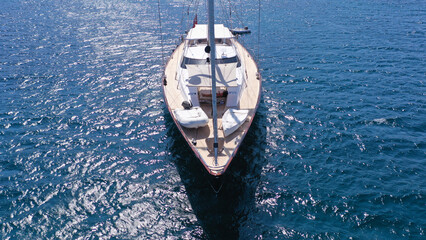 Aerial drone photo of beautiful sail boat anchored in deep blue open ocean sea